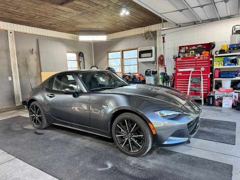 A grey Mazda MX-5 detailed in the shop