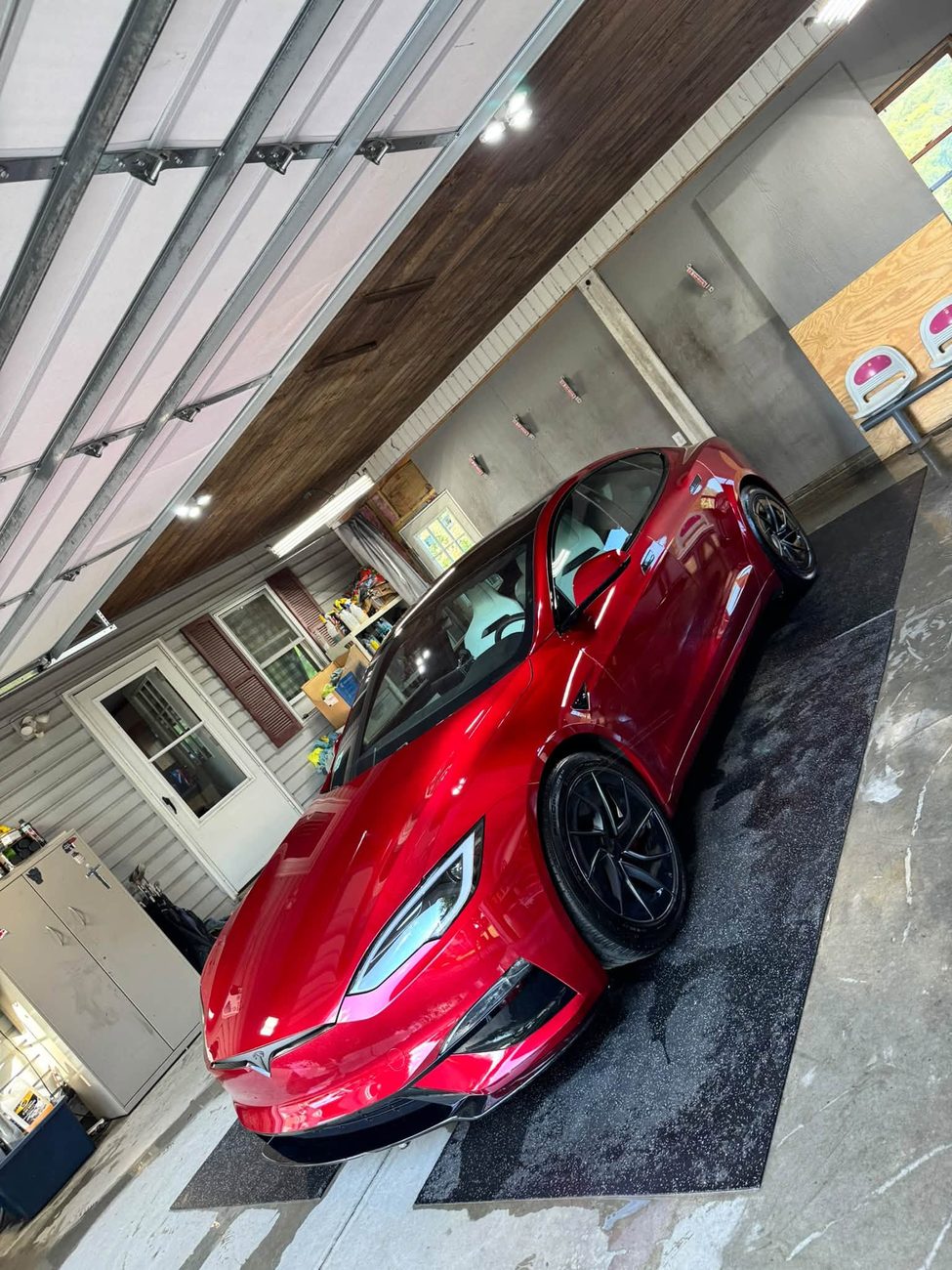 A red Tesla detailed and gleaming in the shop